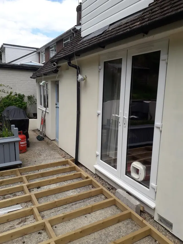 Cream K Rend render finished around white French doors at the back of a house in Gerrards Cross, with new decking frames in front