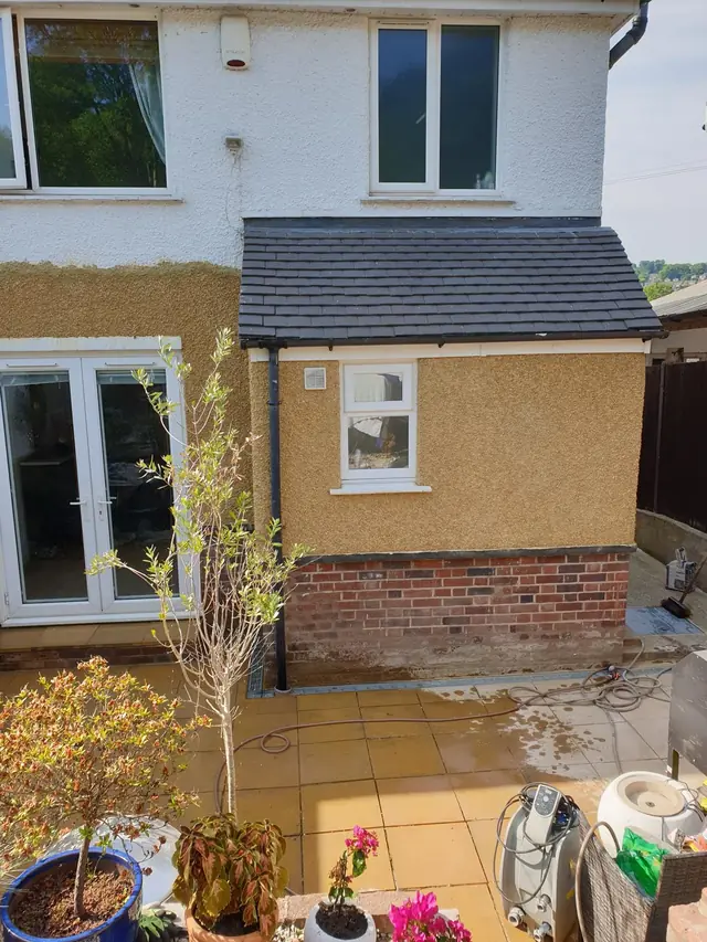 Back of a house in Beaconsfield with a new golden pebble dash finish over the walls and a small extension, above red brickwork